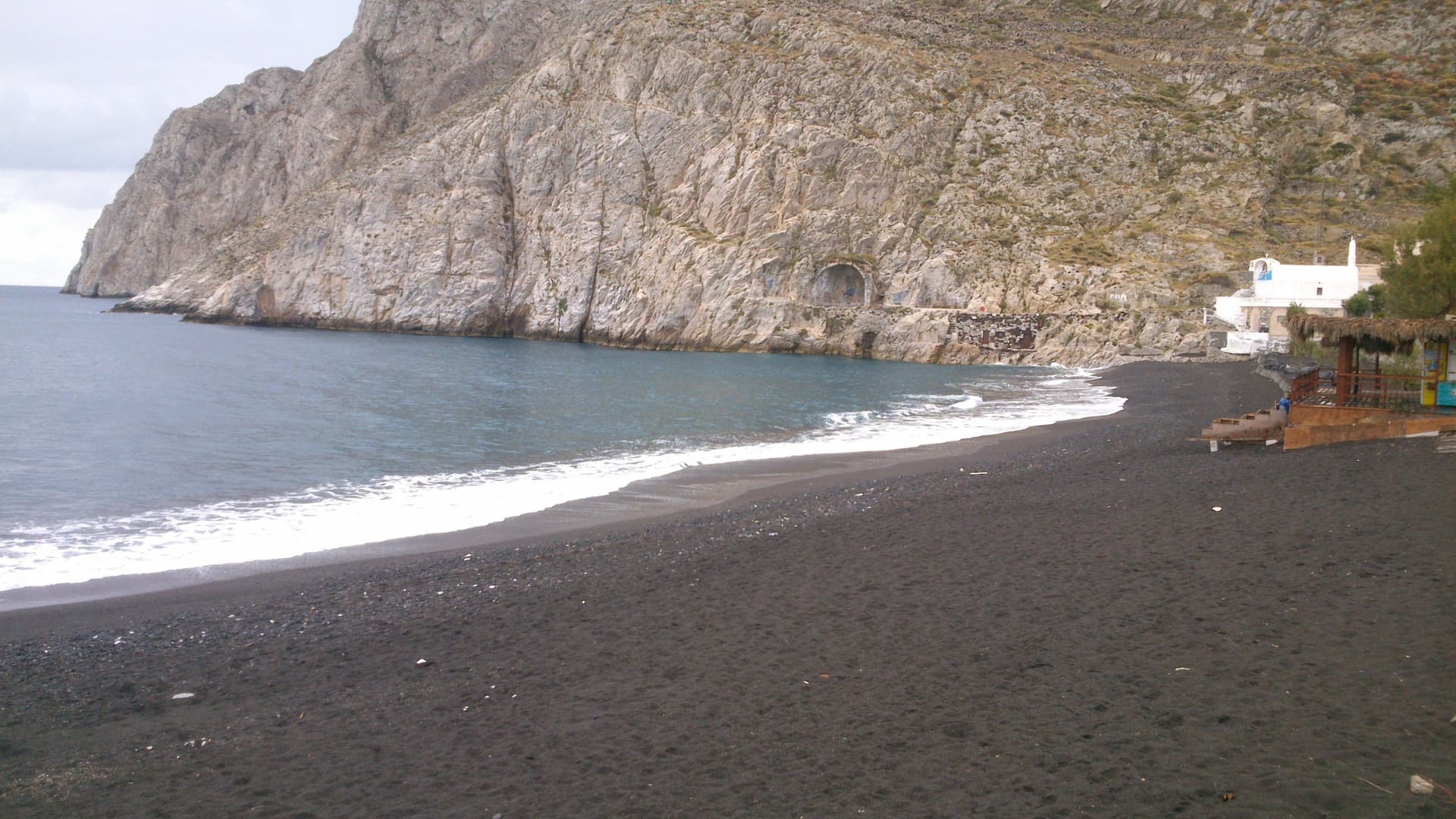 Вулканический песок на пляже Камари